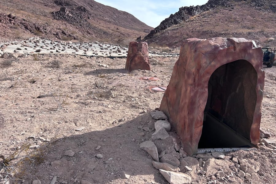 A completed walk-in drinker with a faux rock shade cover in open desert
