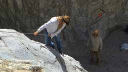 A volunteer digging sand from behind the dam